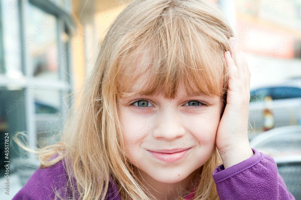 Little blond girl above light city background Little blond girl above light city background