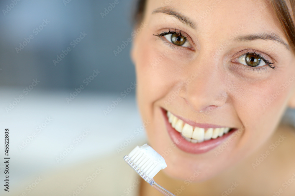 Closeup on woman's toothy smile brushing her teeth Closeup on woman's toothy smile brushing her teeth
