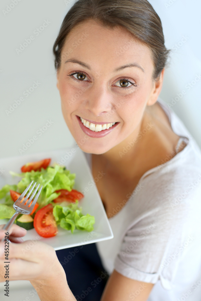 Closeup of cheerful woman eating fresh salad Closeup of cheerful woman eating fresh salad
