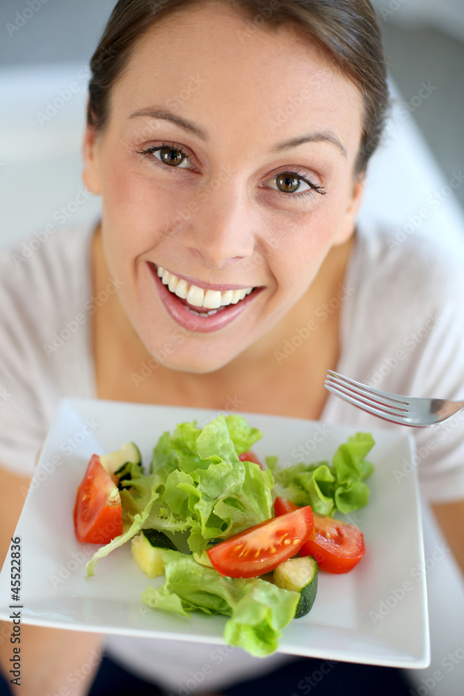 Closeup of cheerful woman eating fresh salad Closeup of cheerful woman eating fresh salad