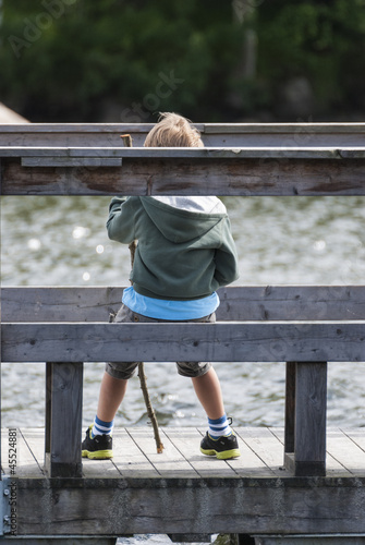 Boy sitting close to a lake