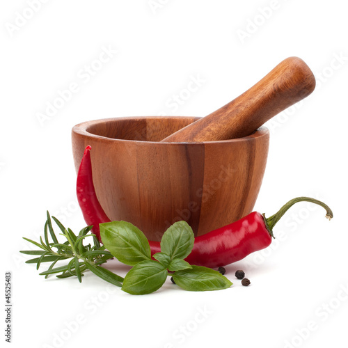 fresh flavoring herbs and spices in wooden mortar