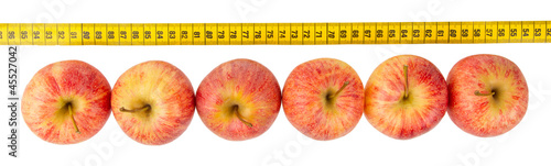 Fotografie Red apples with a yellow tape-measure