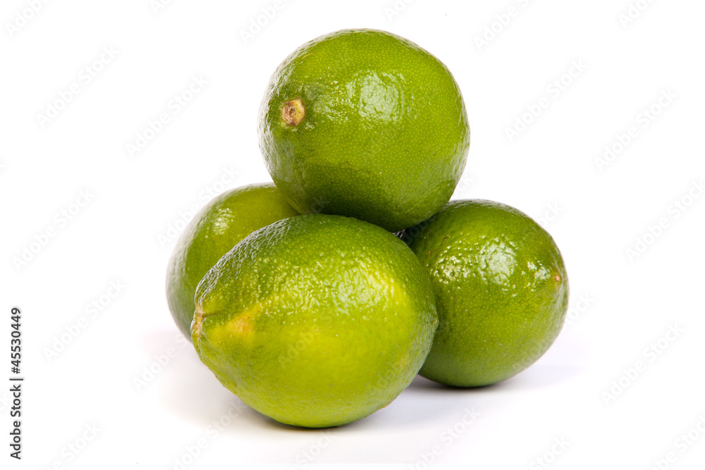 Group of whole limes and one half lime on white Group of whole limes and one half lime on white