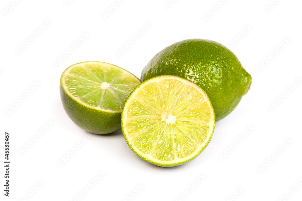 One whole lime and one half lime on white One whole lime and one half lime on white