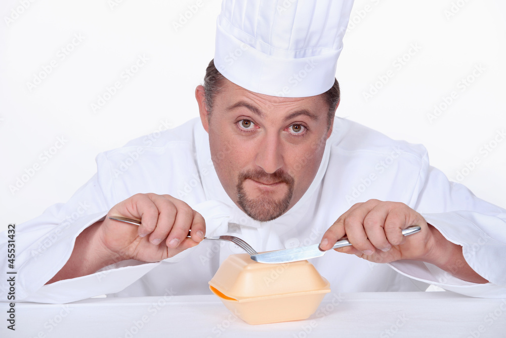 Chef eating a polystyrene foam takeaway box Chef eating a polystyrene foam takeaway box