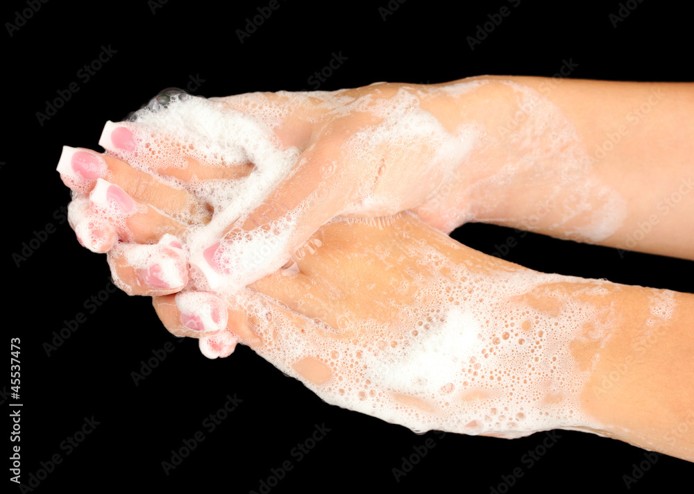 Woman's hands in soapsuds, on black background close-up Woman's hands in soapsuds, on black background close-up