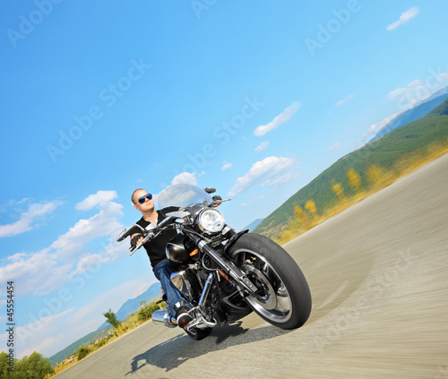 Biker riding a customized motorcycle on a road