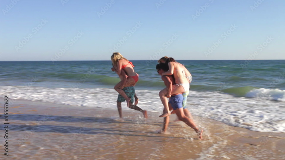 Group Of Teenage Friends Having Piggyback Race Group Of Teenage Friends Having Piggyback Race