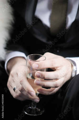 Groom holding wedding champagne glass © Maria Sbytova