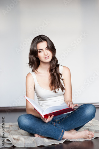 young casual female holding red book