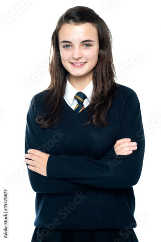 Confident schoolgirl posing with folded arms