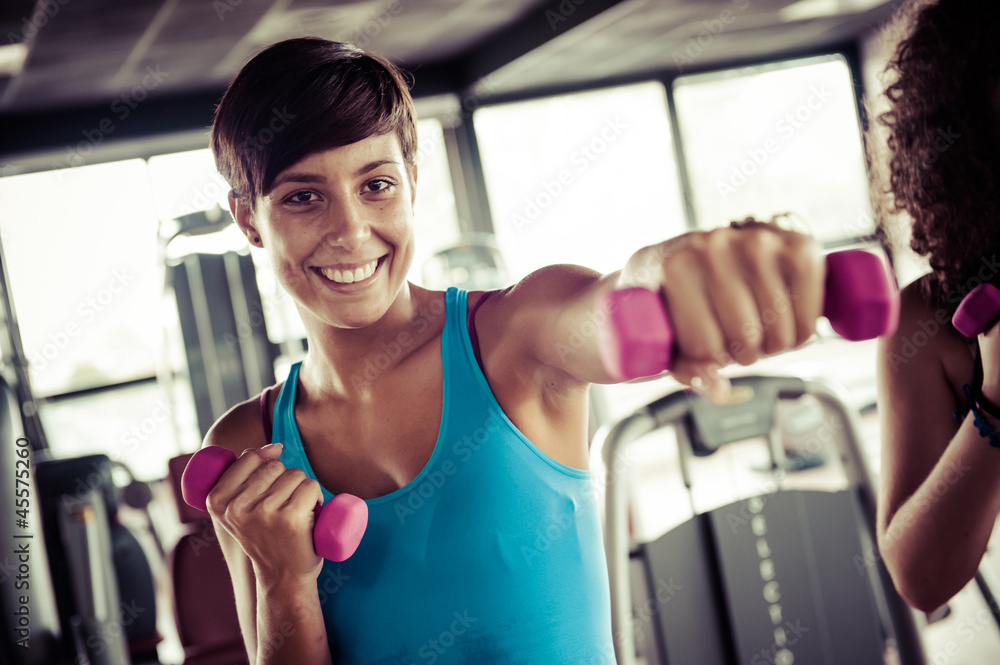 Fototapeta premium Running on treadmill in gym or fitness club - group of women and