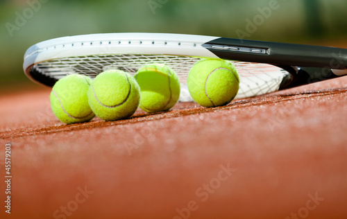 Close up of tennis racquet and balls on the clay tennis court © Karramba Production