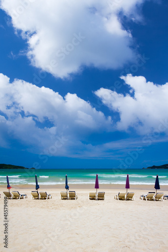 beach chairs on sand beach with cloud