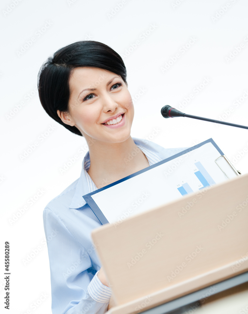 Female lecturer at the podium handing diagram Female lecturer at the podium handing diagram