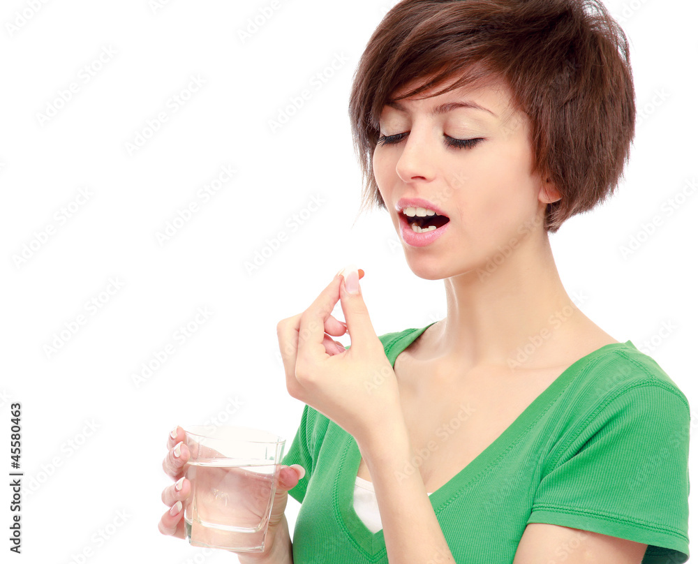 A young girl taking pills, isolated on white A young girl taking pills, isolated on white