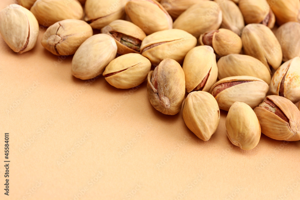 tasty pistachio nuts, on beige background