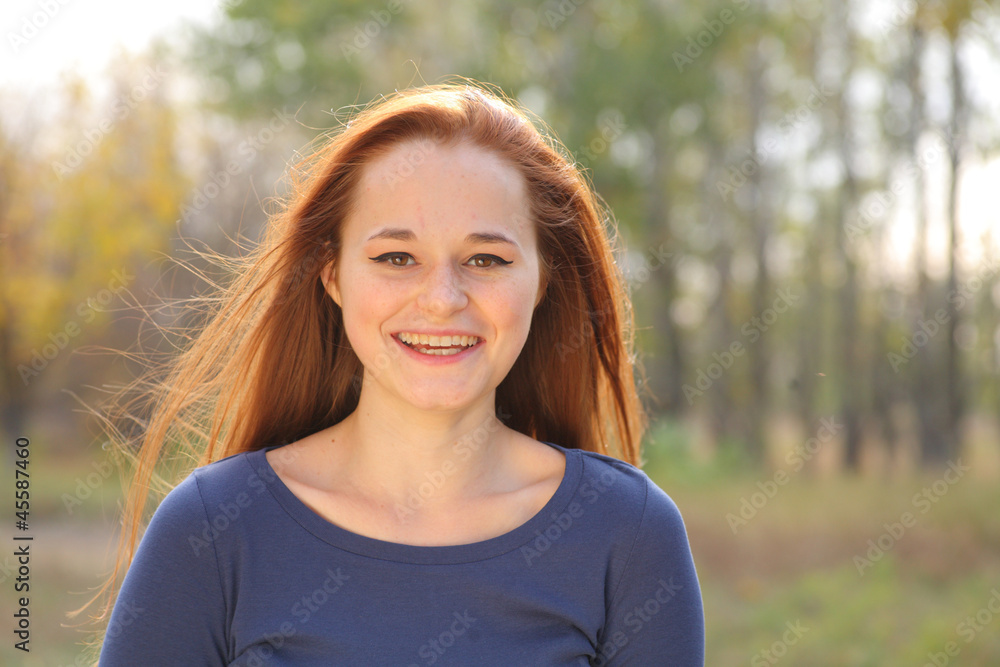 Young redhead woman in the park