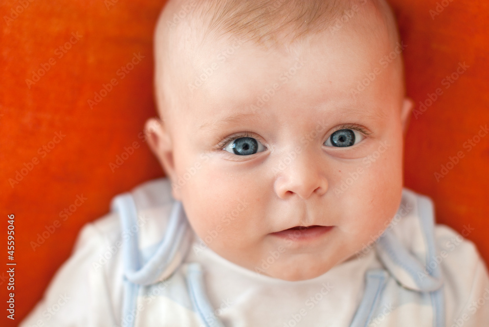 Adorable baby boy on orange background