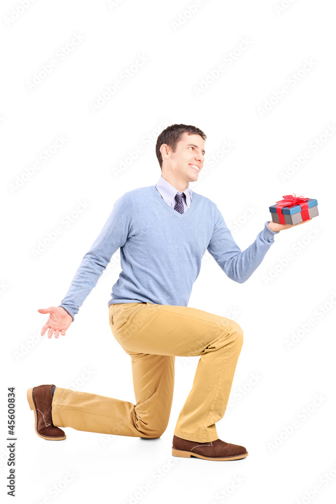 Smiling male practicing a proposal and holding a gift box Smiling male practicing a proposal and holding a gift box