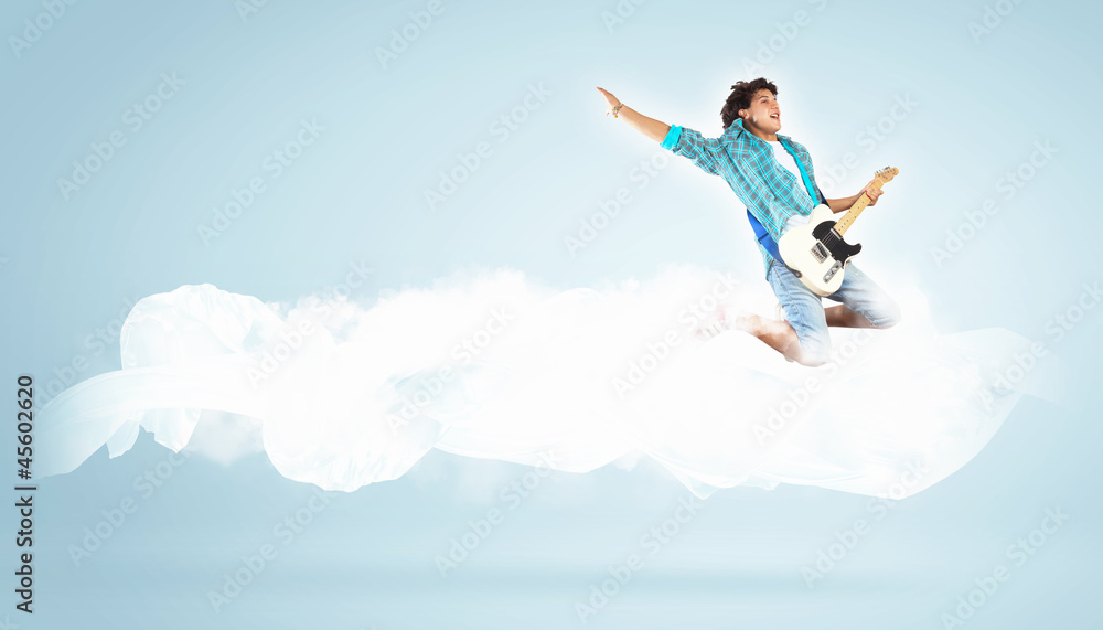 young man playing on electro guitar and jumping young man playing on electro guitar and jumping