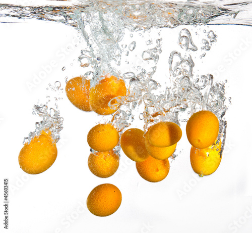 Fototapeta Naklejka Na Ścianę i Meble -  Small oranges falling into water