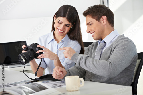 Mann und Frau mit Kamera im Büro photo