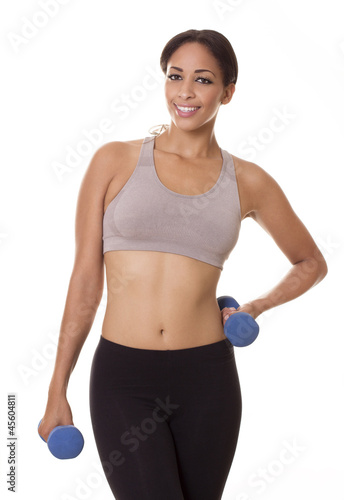Active woman poses in workout clothes with hand weights.