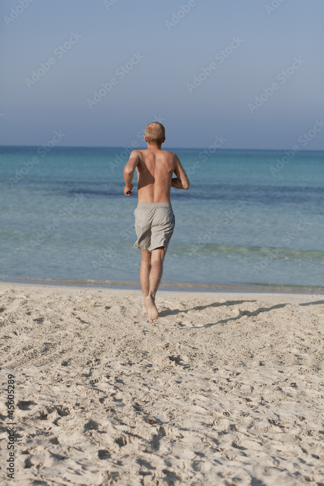 mann rennt am strand im Wasser Hochformat mann rennt am strand im Wasser Hochformat