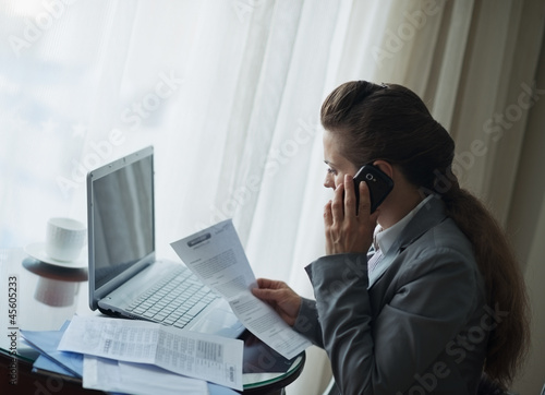 Business woman working and speaking mobile at hotel room