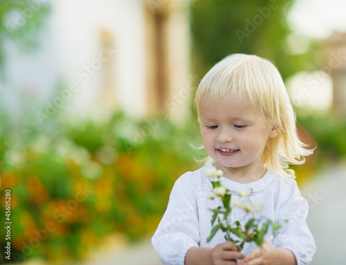 Portrait of baby with flowers outdoors