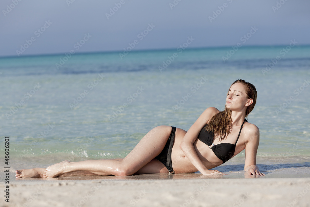 Junge Frau mit schwarzem Bikini am Strand im Wasser Querformat