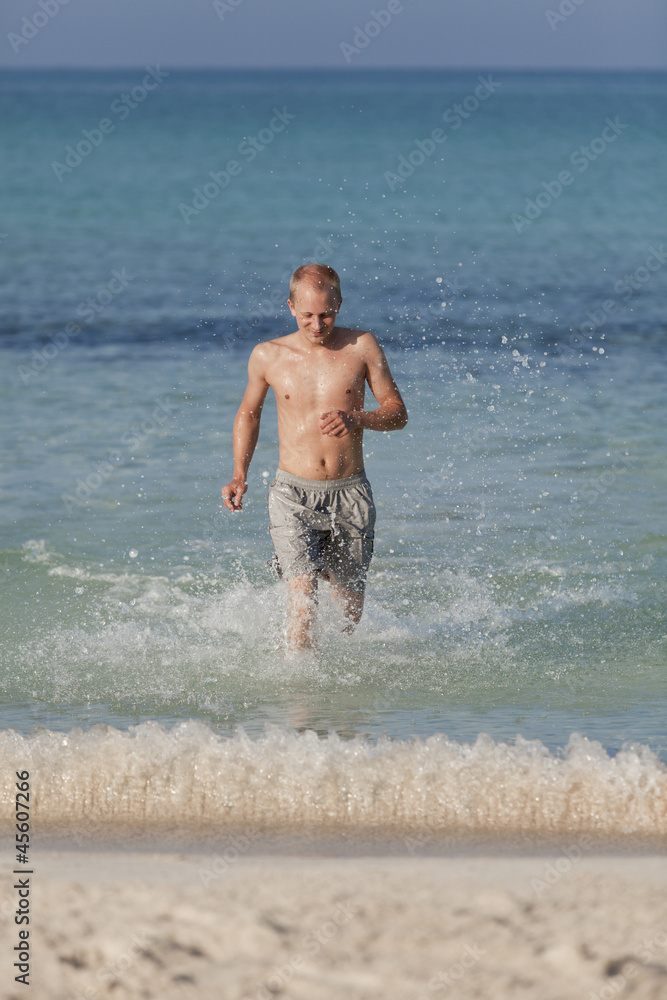mann rennt am strand im Wasser Hochformat mann rennt am strand im Wasser Hochformat