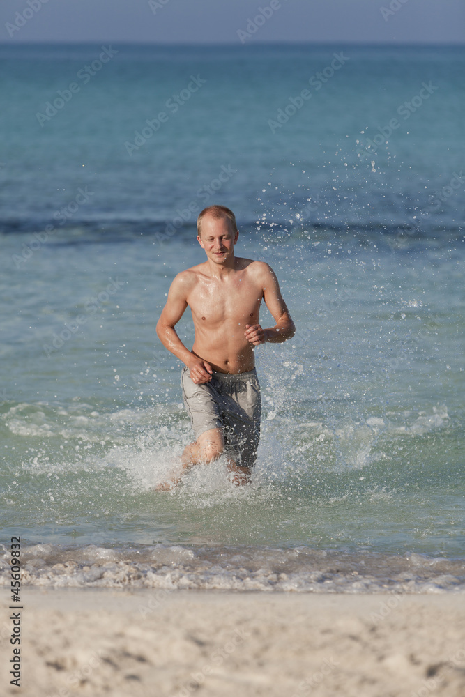 mann rennt am strand im Wasser Hochformat mann rennt am strand im Wasser Hochformat