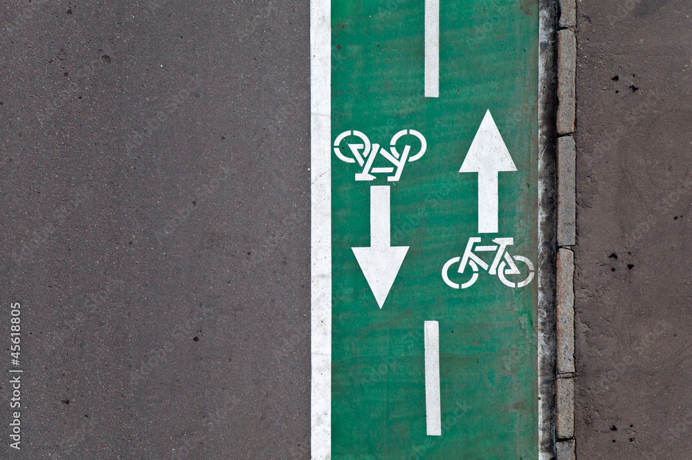 Fototapeta premium Green bicycle lane with road marking background texture