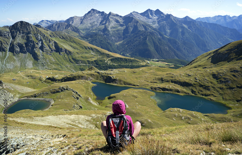 ragazza seduta ammira laghi di montagna Alpi Italia