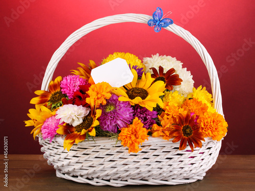 Beautiful bouquet of bright flowers in white basket photo