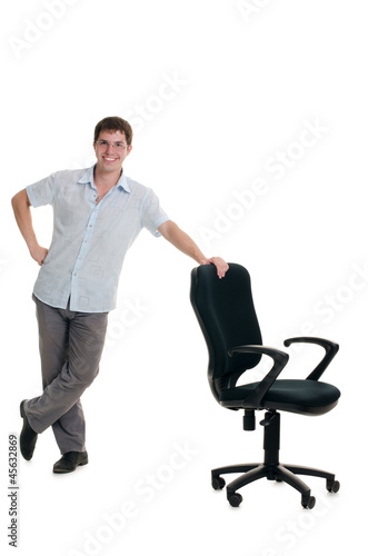 The businessman stands at an armchair