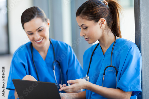 two beautiful female healthcare workers using laptop photo