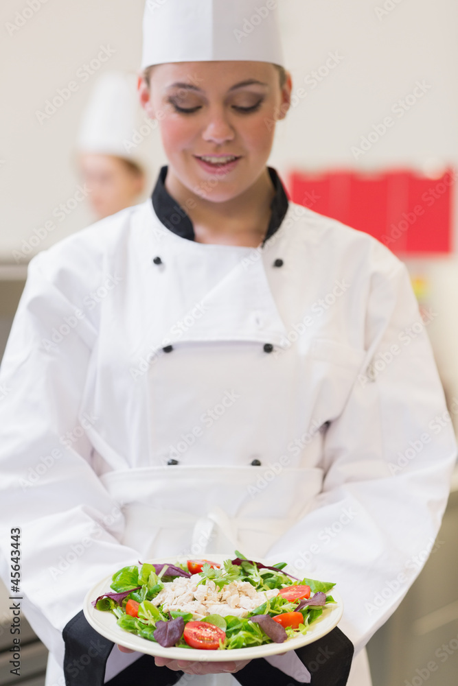 Cheerful chef looking at her salad Cheerful chef looking at her salad