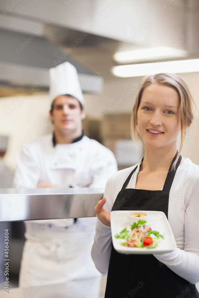 Smiling waitress presenting salmon dish Smiling waitress presenting salmon dish