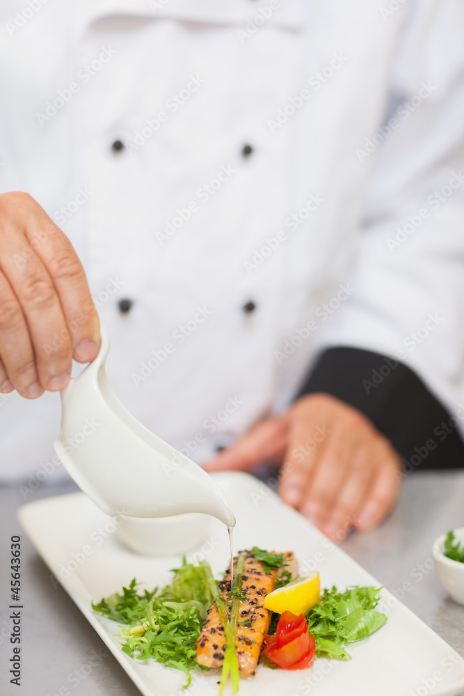 Chef pouring sauce on salmon Chef pouring sauce on salmon