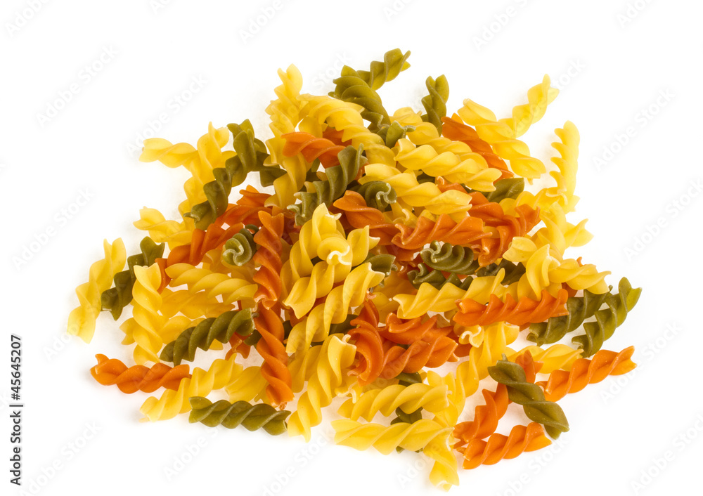 Uncooked pasta fusilli in different colours, white background Uncooked pasta fusilli in different colours, white background