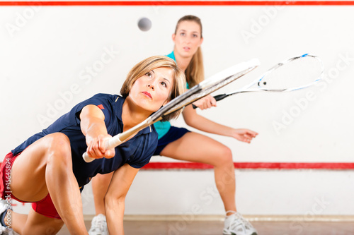 Squash sport - women playing on gym court