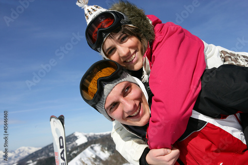 Young couple messing around on the ski slopes