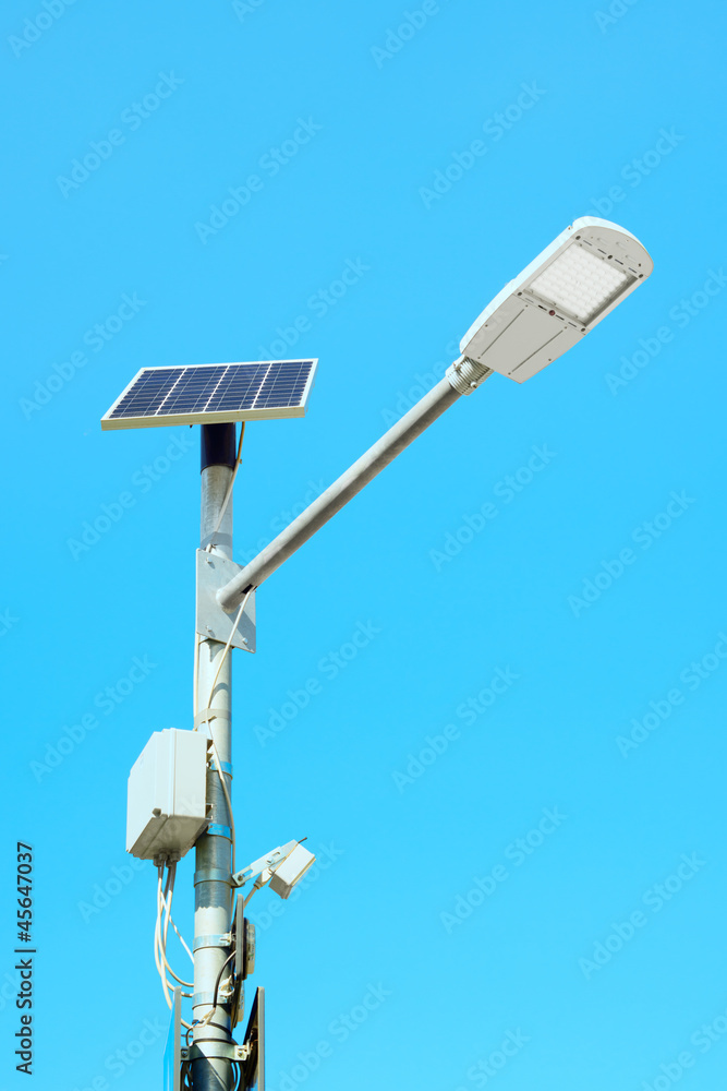 Solar panel powered street lamp on blue sky background Solar panel powered street lamp on blue sky background