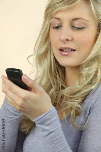 a blonde woman watching her cell phone