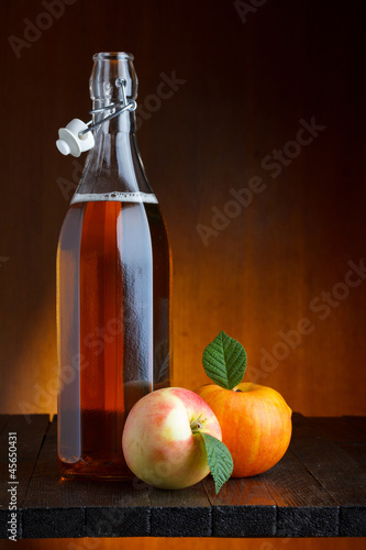 Apple cider bottle with ripe apples