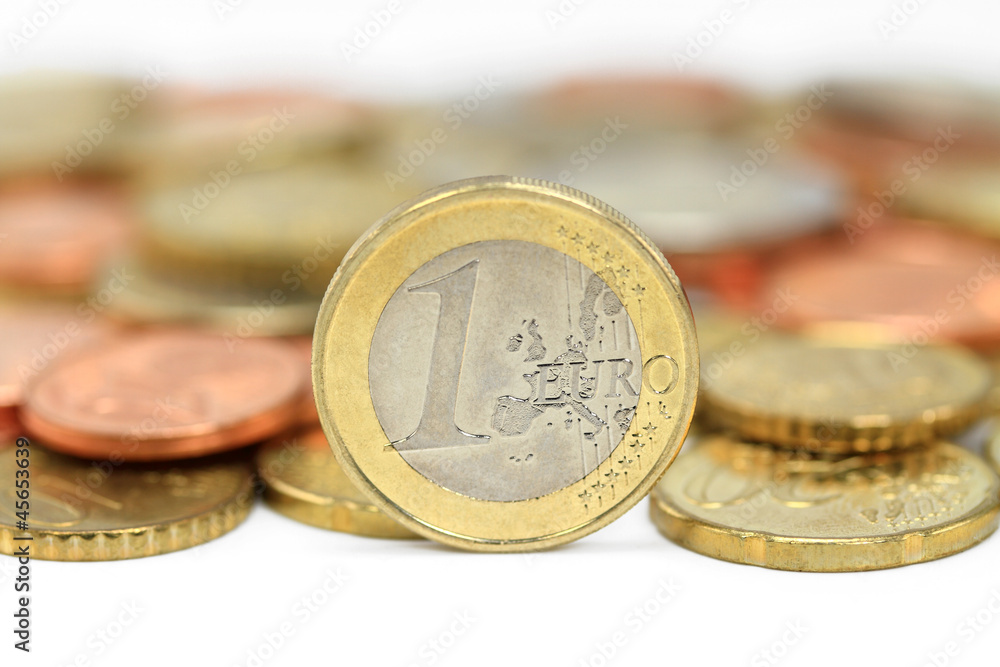 Euro coins. One Euro coin on the foreground. Shallow DOF